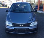 Vue avant gauche du microcar sur parking, phare et pare-chocs visibles