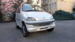 Vue avant de la microcar blanche garée en extérieur