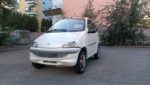 Vue d’ensemble de la microcar garée devant un bâtiment