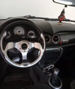 Gros plan sur la portière et la poignée du microcar gris