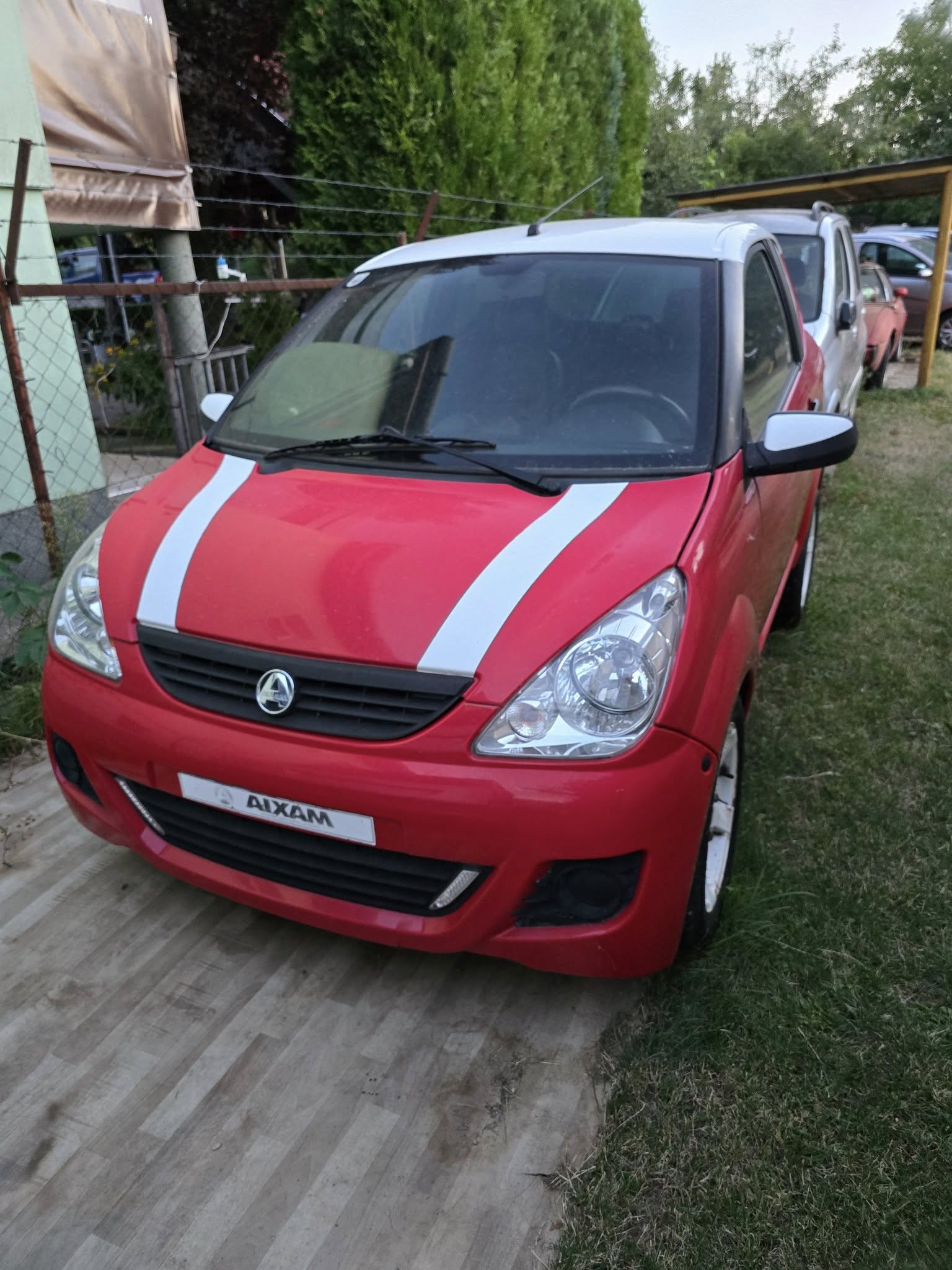 476824808_122199185006233996_2066961650464570184_n-1-1.jpg Vue avant de la microcar rouge avec jantes alliage stationnée