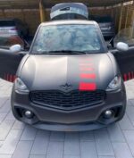 Microcar noire vue avant droite, carrosserie brillante et compacte