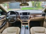 Siège conducteur cuir beige en bon état, vue du volant et des commandes